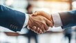 © somneuk - Two business professionals shake hands, symbolizing agreement and partnership in a professional setting.