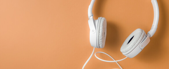 Banner with headphones on orange background and space for text on the right