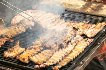 pork ribs grilling outdoors on the grill, outdoor summer party concept