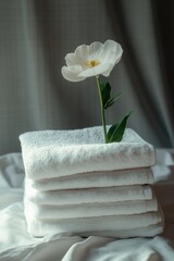 Poster - A pile of crisp white towels topped with a single fresh flower