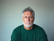 © Amy - Portrait of a mature man with gray hair and a serious expression, wearing a green sweater