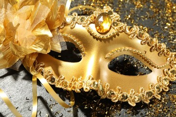 Canvas Print - Beautiful golden carnival mask and confetti on gray textured table, top view