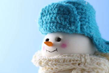 Canvas Print - Cute decorative snowman against light blue background, closeup