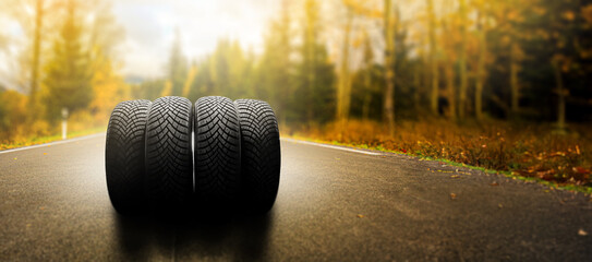 Summer tires on a road winter wheel off. Summer tires on a road winter wheel off. Change a car seasonal tyre summer forest road with trees background. Change for winter tire. Banner Selling off. Or Ba