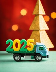 A toy truck carrying three-dimentional digits 2025, a small town and trees in the background. Transport company concept, congratulation, postcard.