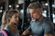 © Milos - A man and woman engage in a serious conversation at a gym, emphasizing the themes of communication, focus, and shared determination in physical training.