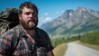 © logyartstudios - A bearded man with a backpack stands on the side of a road in a mountainous area.