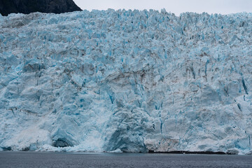 Aialik Glacier landscape with Aialik Bay and surrounding mountains in Kenai Fjords National Park leading to the Harding Icefield near Seward, Alaska - blue glacier texture 