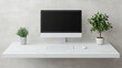 © Marketplace - Modern workspace featuring a sleek computer monitor, keyboard, and potted plants on a minimalist desk against a muted concrete backdrop.