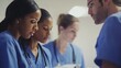 © logyartstudios - A group of medical professionals in blue scrubs huddle together, discussing a patient's chart.