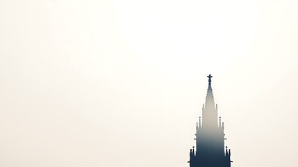 A tall, spire-shaped building with intricate details stands against a clear, white sky.