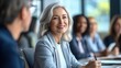 © paper later - A middle-aged woman with grey hair smiling at a meeting