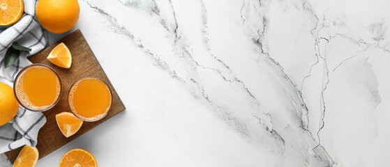 Wall Mural - Wooden board with glasses of tasty juice and fresh oranges on white marble background