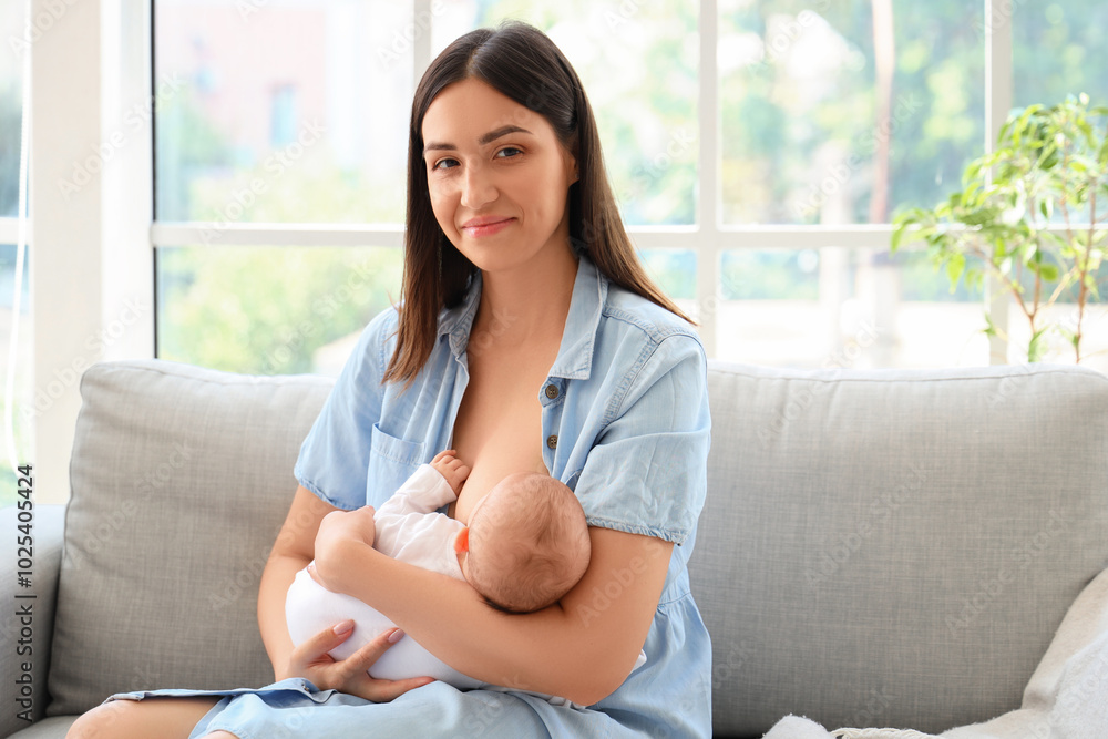 Young woman breastfeeding her baby at home
