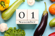 © Pixel-Shot - Fresh vegetables, fruits and cube calendar with date NOVEMBER 1 on blue background. World Vegan Day concept