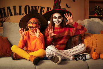 Scary little girls dressed for Halloween at home in evening