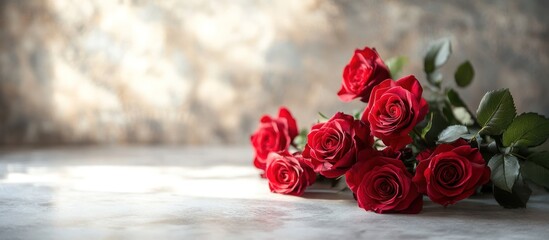 Canvas Print - A bouquet of red roses laying on a white surface with a blurred background.