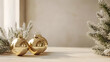 © The Origin 33 - Golden metallic baubles on neutral surface with festive greenery