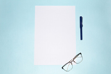 A blank sheet of paper, a fancy pen and glasses on a flat blue background.