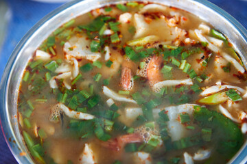 Spicy Tom Yum Goong  Famous Thai food with ingredient in a bowl