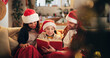© Flashizzle/peopleimages.com - Christmas, family and happy on sofa with book, funny storytelling and reading together. Parents, child and support in home with novel, literature humor and love at festive season with comedy on couch