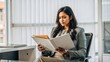 © Htet Wai Phyo - India  business lady boss serious reading about new project at modern office , folding hand and reading paper while sitting on chair,  lot of files on desk, copy space