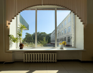 Wall Mural - A window with a plant in a vase and a radiator in front of it