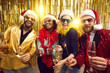 © Studio Romantic - Young excited diverse friends celebrating Christmas or New year eve together Happy multiracial people group in party santa claus hat holding sparklers and champagne glasses having fun