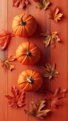 Canvas Print -  A collection of orange pumpkins atop a wooden table, surrounded by autumn leaves and a solitary maple leaf