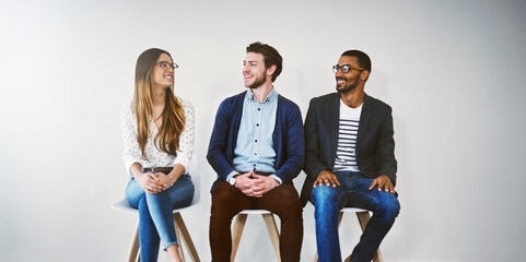 Canvas Print - Row, chair and group in waiting room, smile and professional in business, recruitment and talking. Appointment, applicant and people in line, job interview and process of hiring and onboarding