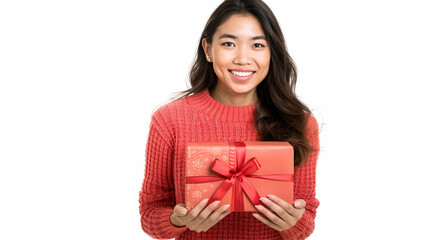 A cheerful woman wearing a red sweater holds a wrapped gift box with a ribbon, expressing joy and celebration against a white background.
