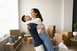 © fizkes - Dream come true. Laughing candid couple in love hugging at new own rented apartment boyfriend lift girlfriend up in air excited with life changes becoming homeowners purchasing flat in joint property