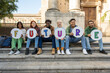 © Lomb - Diverse students holding future signs, multicultural youth group on university campus steps