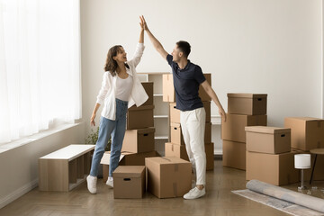 successful new milestone. excited young married couple renters tenants homeowners stand in living ro