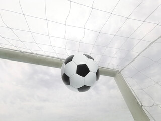 A soccer ball flies into the goal. Football player shoots leather soccer ball to score