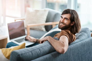 Portrait, remote work from home and man on sofa, laptop and smile with connection in living room. Face, person and freelancer on couch, computer and research for project and website info in lounge