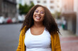© Sanc/peopleimages.com - Portrait, laugh and woman in city with glasses for fashion, style and travel outdoor. Face, funny and African student with spectacles on urban street for vision, casual clothes and excited in Kenya
