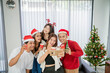 © Odua Images - boys and girls taking picture together at christmas party using handphone