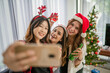 © Odua Images - group of asian females taking photo during christmas party