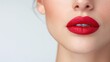 © DuangphonKPR - A close-up of a woman's lips featuring vibrant red lipstick, showcasing smooth skin and a soft, polished look against a light background.