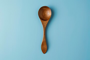 Wooden spoon on a light blue background showcasing its elegant shape and craftsmanship