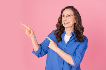 Poster - Photo portrait of lovely senior lady look point empty space dressed stylish blue garment isolated on pink color background