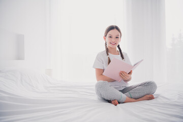 Canvas Print - Portrait of adorable lovely girl holding literature reading book cozy bedroom flat white light room interior indoors