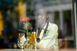 © AstrorickyPhotograpy - Young woman of color dreadlocks cafeteria window reflections cocktail