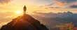 © Prichachai - Silhouette of a person standing on a mountain peak at sunrise, overlooking a serene landscape with distant mountains and a colorful sky.