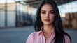 © liliyabatyrova - A woman with long black hair and a pink shirt is standing in front of a building