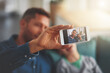 © JordaanExams/peopleimages.com - Family, phone screen for selfie with father and son on sofa in living room of home together for bonding. App, display and hand of single parent man with boy child for love, memory or photograph