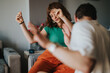 © qunica.com - A joyful scene of two friends dancing in a cozy living room, expressing happiness and carefree enjoyment in their comfortable home environment.
