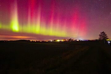 Wall Mural - northern lights dancing over couhtry landscape