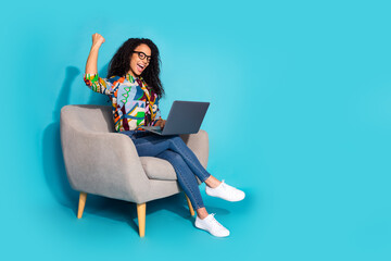 Photo of pretty cute cheerful woman wear stylish clothes sit armchair pass exam yes netbook isolated on blue color background